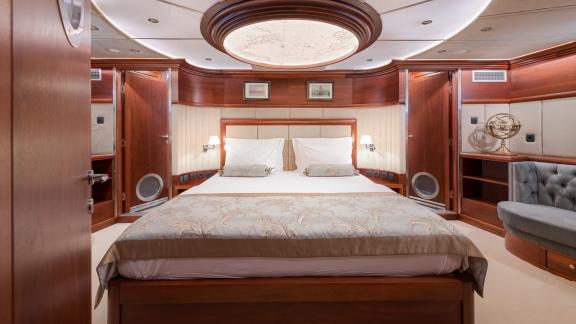 A discreetly decorated, comfortable double bed stands under the round luxury glass lamp in the master stateroom.